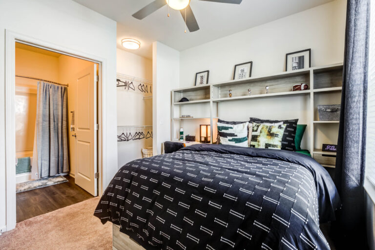 Cozy bedroom with shelving unit and connecting bathroom 768x512 1